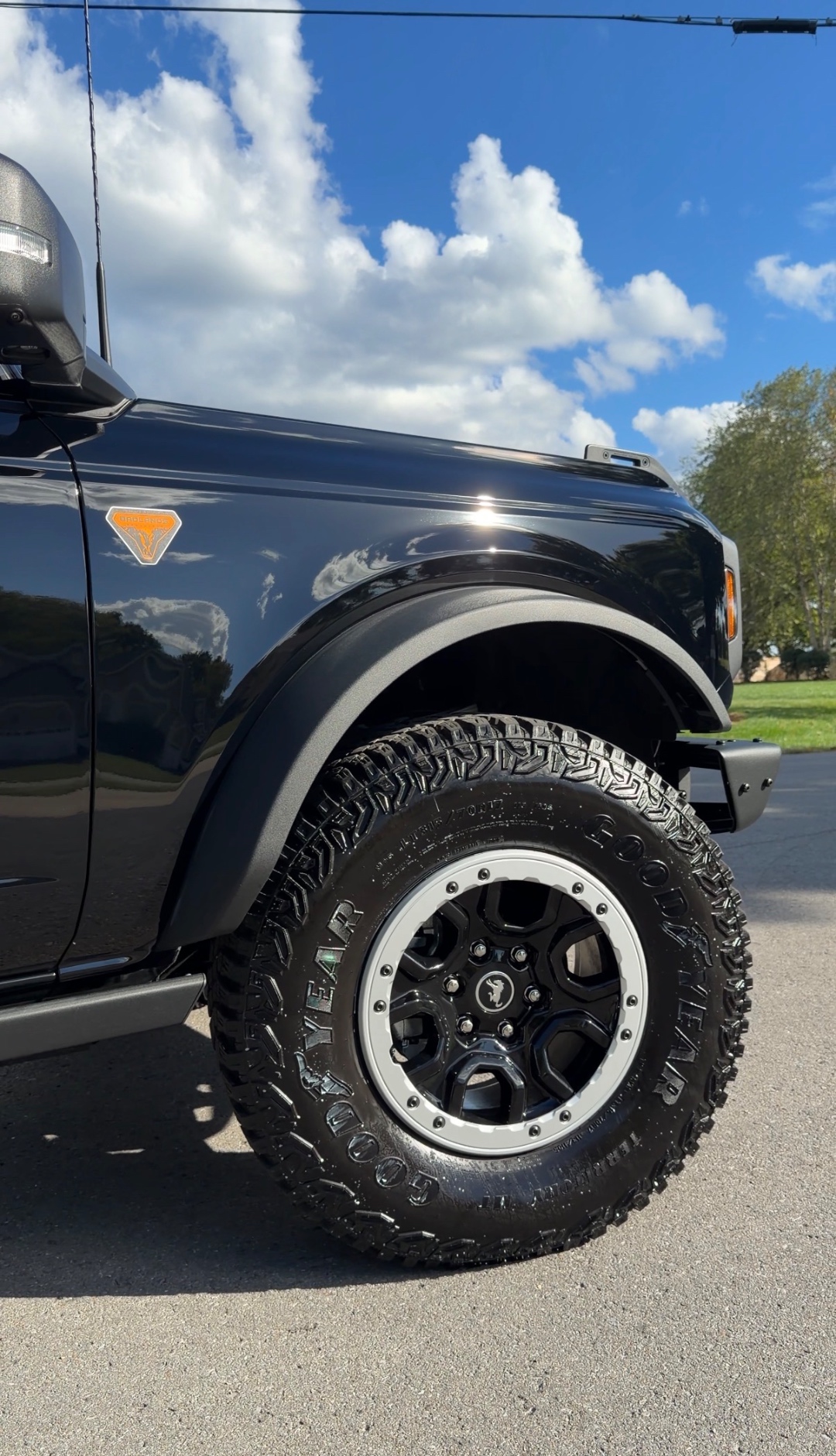 Ford Bronco glossy wheel and paint close-up against blue sky