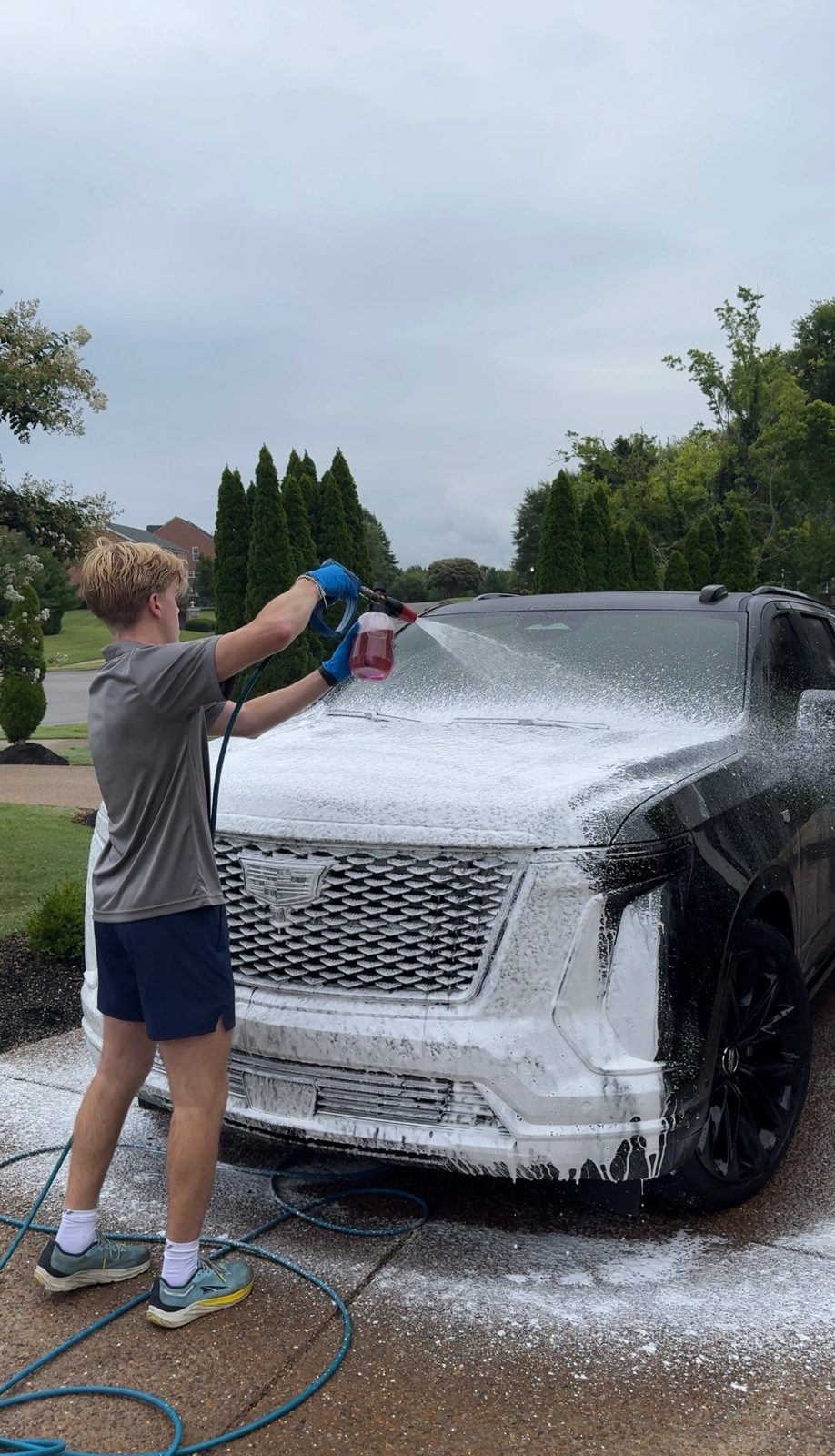 Brody Hitchcock applying foam wash to a black Cadillac Escalade during a mobile detail in Nashville
