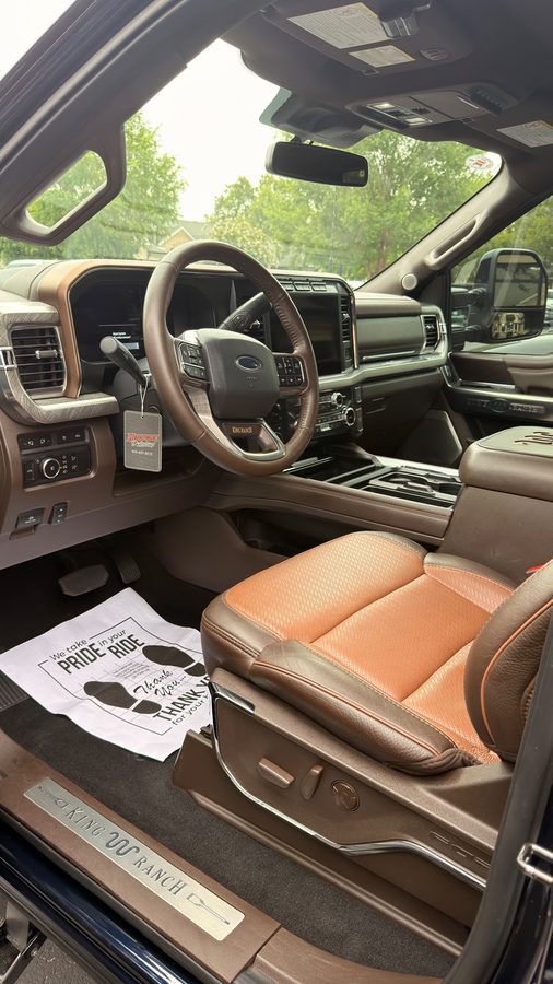 Ford F-250 King Ranch interior after a deep clean, with a Hitchcock Detailing tag and floor mat