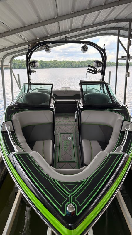 Wakeboat detailed in its boat house on the lake